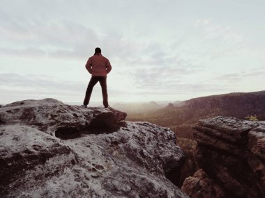 Bir kayalık dağ Zirvesi ayakta, sabah sis izlerken uzun yürüyüşe çıkan kimse 