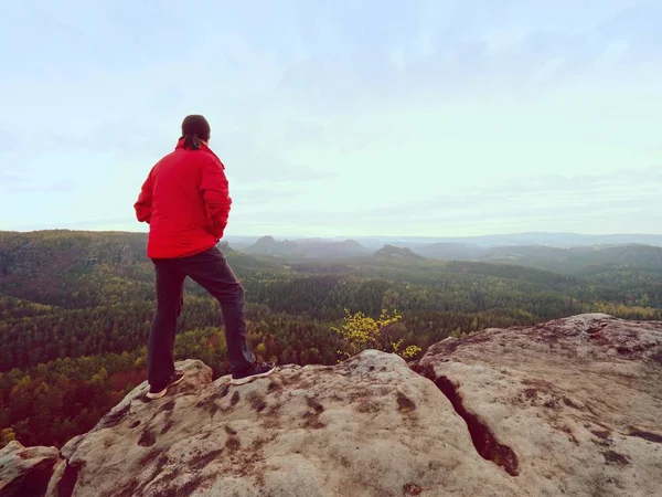 Wanderer steht auf einem felsigen Berggipfel und beobachtet den Morgennebel — Stockfoto