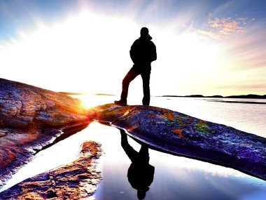 Adam denizde. Gökyüzü ve adam düzgün bir su yansır 