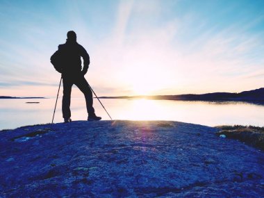 Sahil güzel yaz günbatımında. Adam karşı günbatımı okyanus, sırt çantası ile ayakta. 