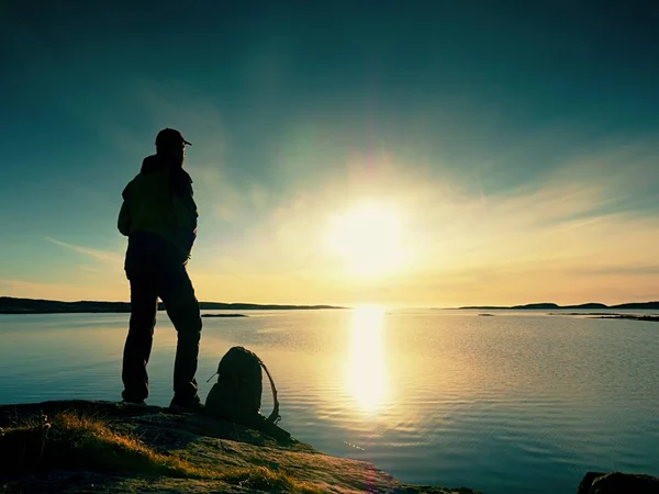 Beautiful summer sunset at seaside. Standing man with backpack at ocean against  sunset. — Stock Photo, Image