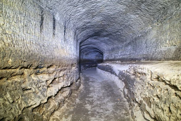 El viejo túnel de agua, cuevas minadas. La cueva. túnel de arenisca paredes humedecidas . — Foto de Stock