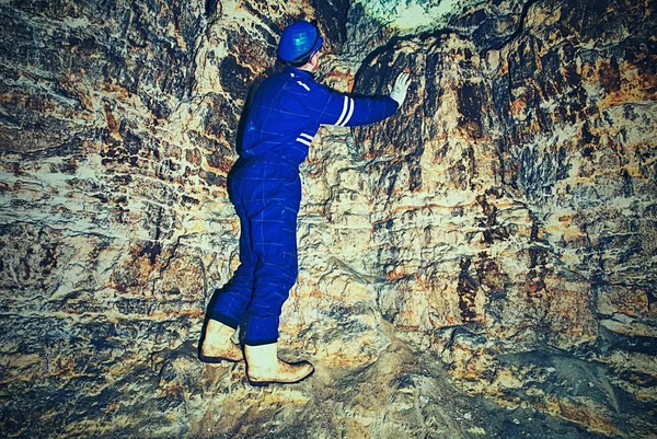 Menschen arbeiten unterirdisch in dunklen Tunneln. Mitarbeiter im Schutzanzug prüfen Sedimente — Stockfoto