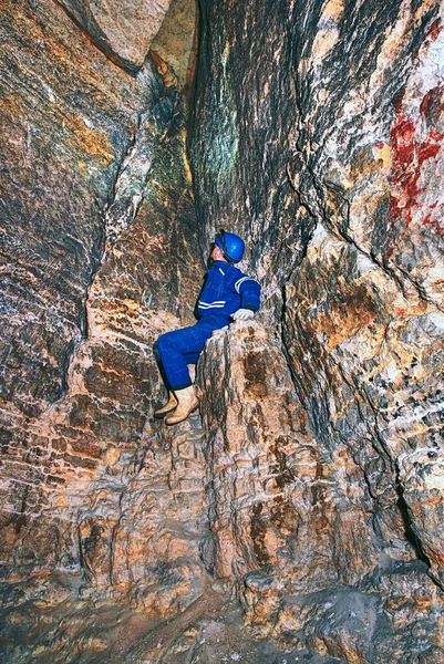 Člověk pracovat pod zemí do temného tunelu. Zaměstnanci v ochranný oblek zkontrolovat sedimentech — Stock fotografie