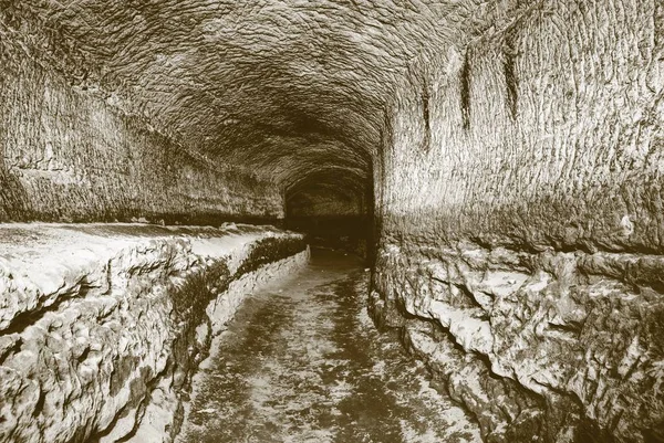 El viejo túnel de agua, cuevas minadas. La cueva. túnel de arenisca paredes humedecidas . — Foto de Stock