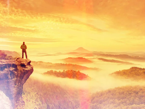 Αφηρημένη επίδραση. Ο άνθρωπος μείνετε στην κορυφή εντός Χαραυγή και να παρακολουθήσουν πάνω από το ομιχλώδες τοπίο. Όμορφο φθινόπωρο — Φωτογραφία Αρχείου