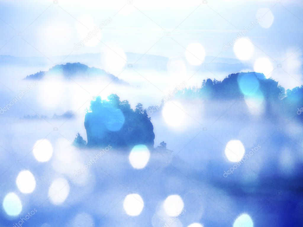 Abstract effect. Dreamy landscape lost in thick fog. Fantastic morning glowing by sunlight