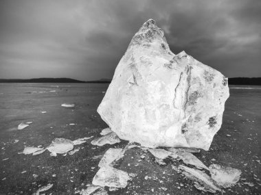 Karanlık bir yansıtıcı yere buz küpleri. Parlayan adet kıyılmış buz ve kar taneleri 