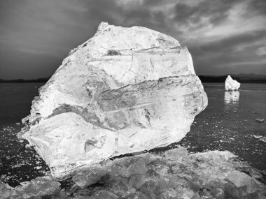 Karanlık bir yansıtıcı yere buz küpleri. Parlayan adet kıyılmış buz ve kar taneleri 