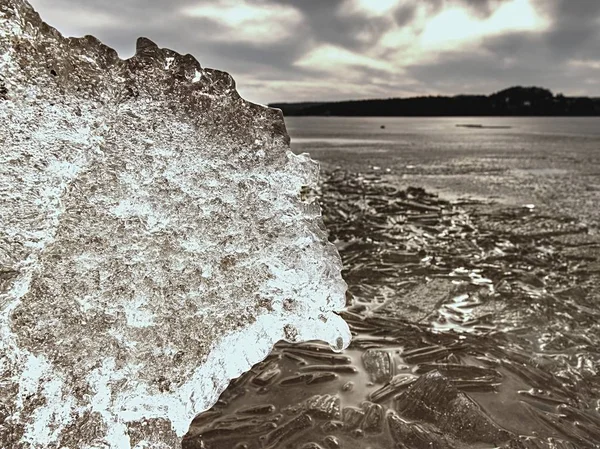 Praia congelada no dia de inverno frio com gelo colorido. Ondas geladas congeladas rochas cobertas — Fotografia de Stock