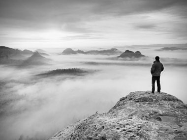 Fiyatı kayalık tepe üzerinde. Ağır Sis derin vadi içinde harika daybreak dağlarda. . Siyah ve beyaz fotoğraf.