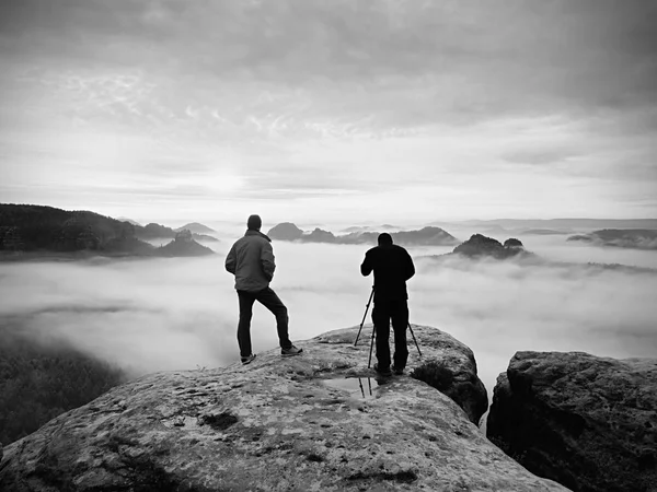 Siluetas de fotógrafos. Hombres en la montaña, dos hombres tomando fotos en otoño amanecer por la mañana — Foto de Stock