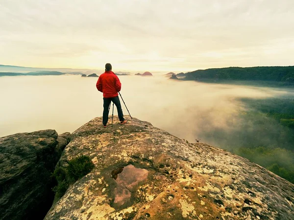 Photographer silhouette above a clouds sea, misty mountains — Stock Photo, Image