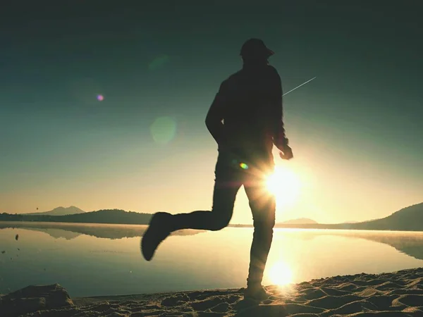 Man joggen op het strand tijdens de late namiddag. Jonge gespierde bouwen man — Stockfoto