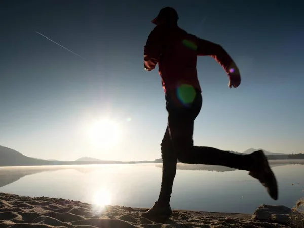 Hombre corriendo en la playa durante la tarde. Joven musculoso construir hombre — Foto de Stock