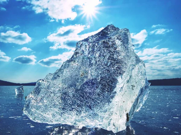 Un morceau de glace tranchant. Symbole d'un hiver rigoureux. Les rayons du soleil forment des ombres arc-en-ciel — Photo