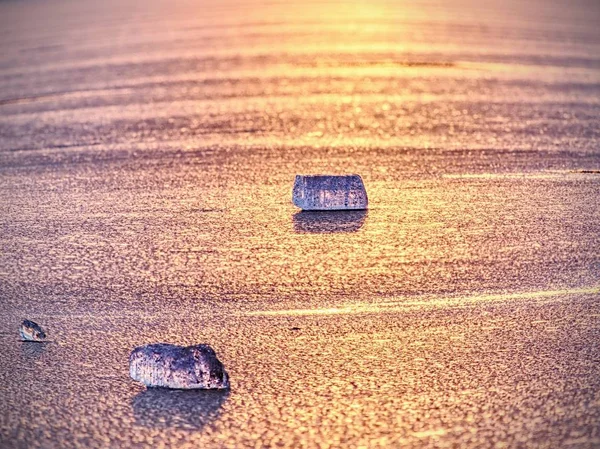 Hielo frío brillante, carámbanos brillantes en la orilla del lago congelado. Cálidos rayos de sol al atardecer. Reflexión —  Fotos de Stock