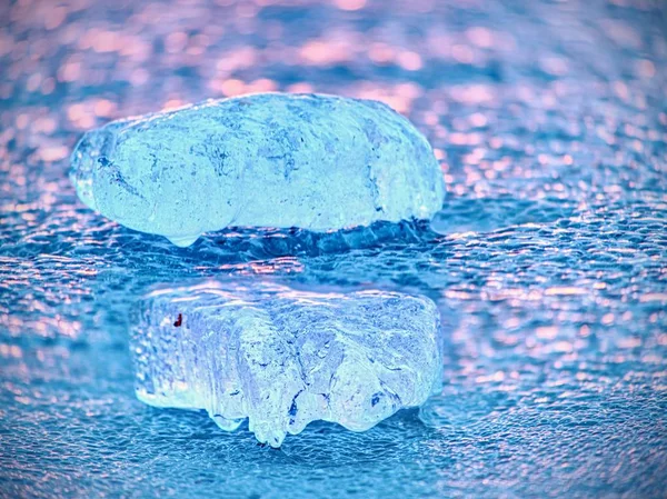 Glänzend kalte Eisstücke auf einer klaren Eisscholle. Struktur des natürlichen Eises im selektiven Fokus — Stockfoto