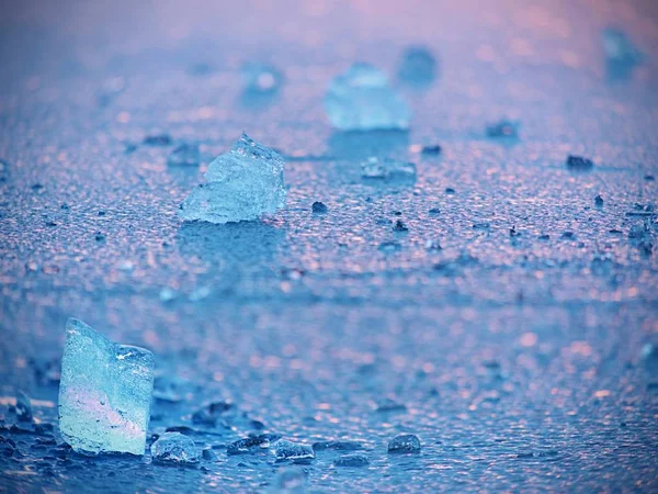 Selektiv fokus till isflaken reflekterat sunset färger. Is på slät vattenytan. — Stockfoto