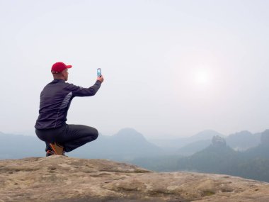 Ayna kamera ve tripod kaya tepe üzerinde çalışma fotoğrafçı. Rüya gibi sis