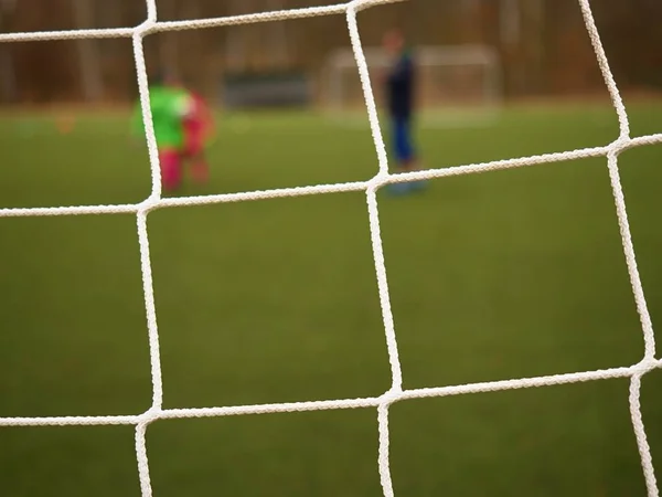 Jogador de futebol está contra o gol com net e estádio. Rede de portões de futebol. Portão de futebol — Fotografia de Stock