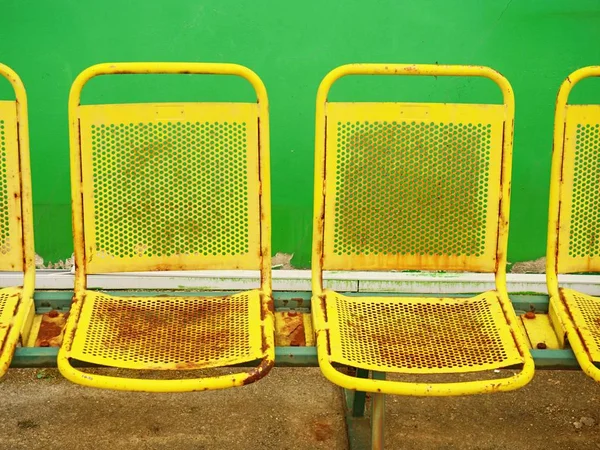 Staré žluté rezavé kovové míst na venkovní stadion. Židle lavice hráči — Stock fotografie