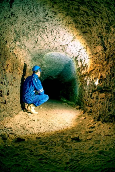 Workerman with helmet and protective suit using glowes and strong head lamp. Man do job — Stock Photo, Image