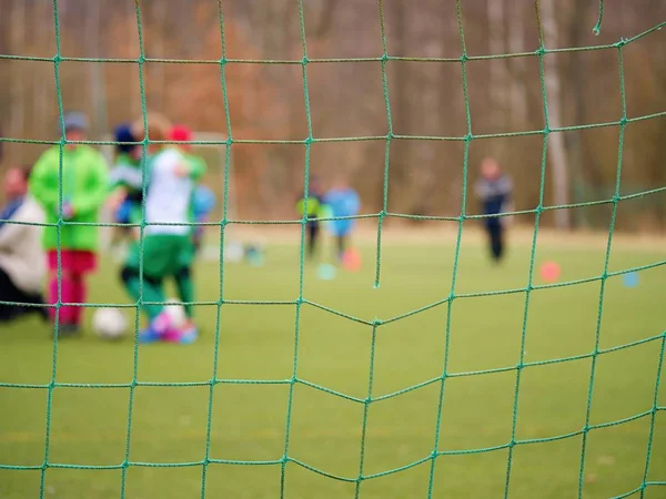 Football training.  Crossed soccer nets soccer football in goal net with grass