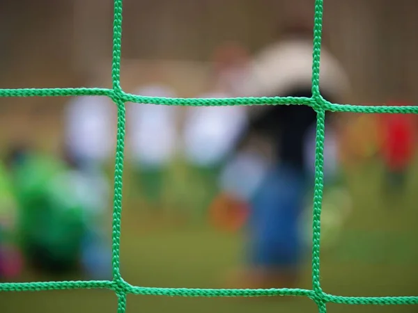 Fotbalový obránce stojí proti cíl s net a stadion. Fotbalová brána čisté. Fotbalová brána — Stock fotografie
