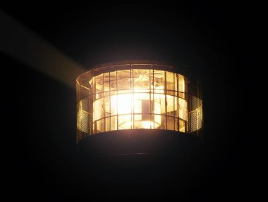 Parlayan deniz feneri lambası. Cam halkalardan yapılmış Fresnel lensler. Kapalı gece görüntüsü