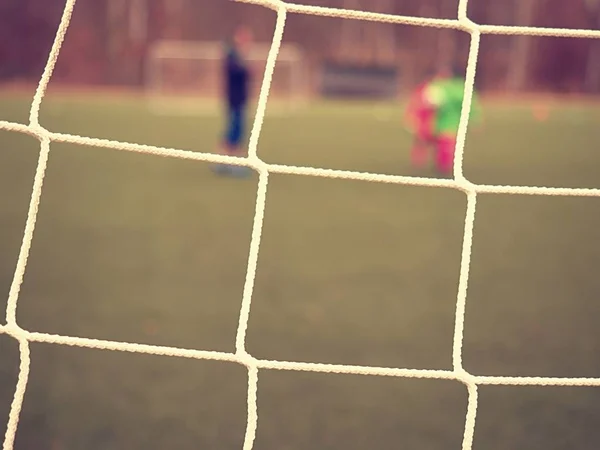 Close-up detail van een voetbal netto tegen groen gras op een bewolkte dag. — Stockfoto
