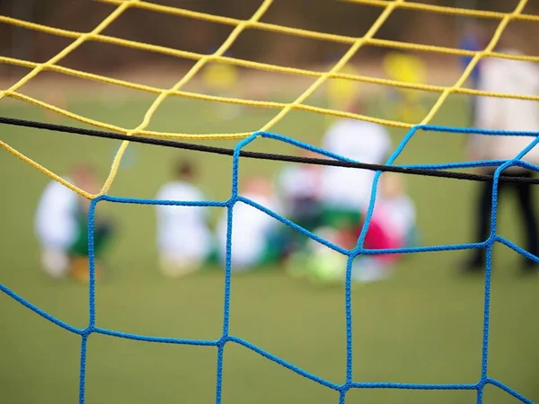 Football training.  Crossed soccer nets soccer football in goal net with grass