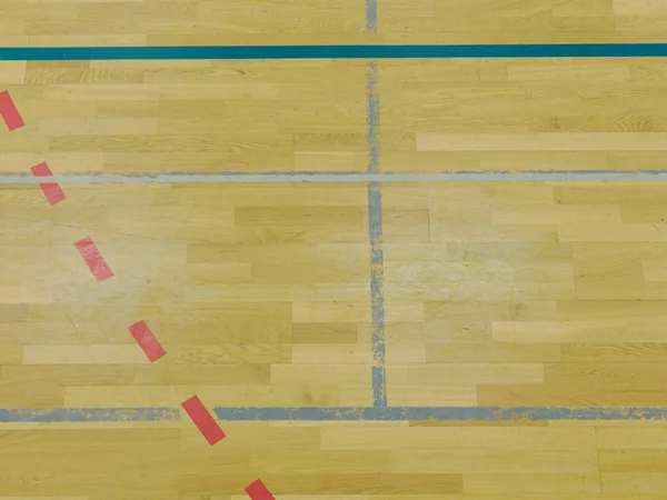 Дерев'яна підлога в спортивному залі з суцільними і пунктирними лініями. Світлове відображення — стокове фото