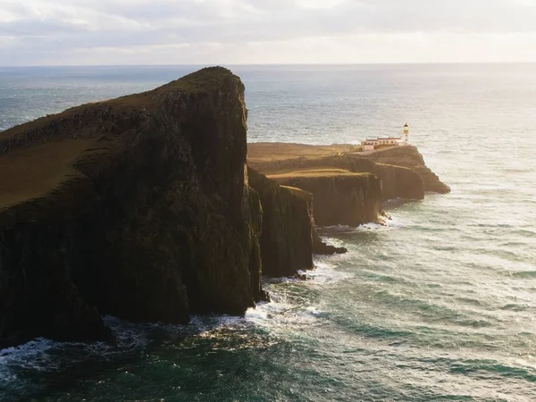 Vieux phare au bout d'une mince flèche de terre. Forte falaise rocheuse aganst à l'océan mousseux — Photo