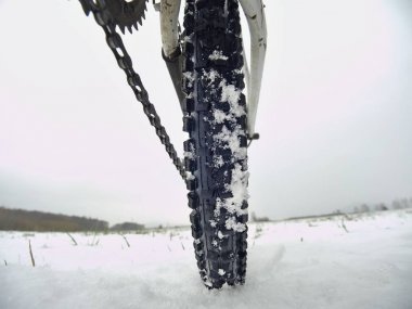 Düşük ayak bileği fotoğraf mtb rüzgârla oluşan kar yığını içinde arka hweel. Resmi kış bisiklet gezisi içinde alınan