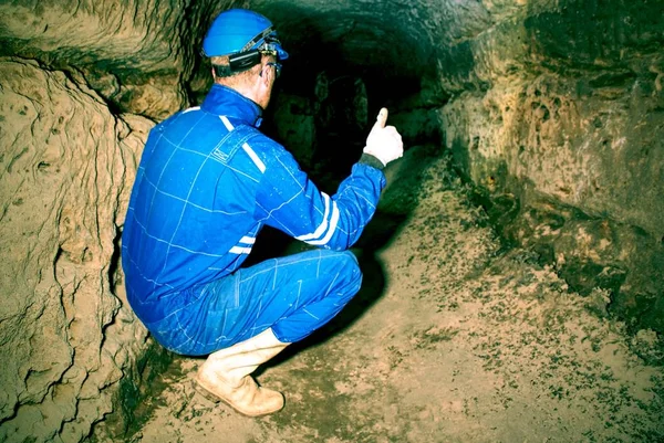 L'homme travaille dans un ancien tunnel mystique à partir de murs de grès orange, ville souterraine . — Photo