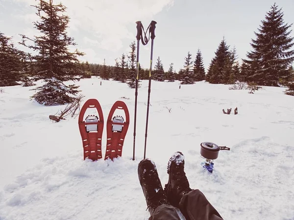 Lunch time during winter trail. Camping on snow and cooking. Red snowshoes — Stock Photo, Image