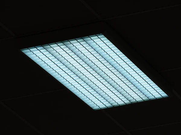 Lichtdecke aus quadratischen Paneelen. Leuchtstofflampen an der modernen Decke. — Stockfoto