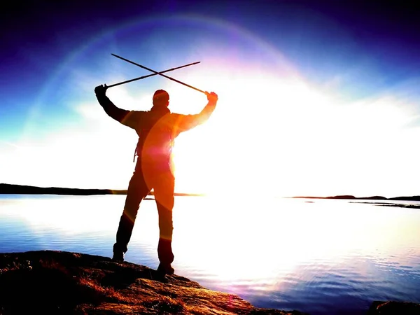 Man at sea. The sky and the man are reflected in a smooth water in front of the sea.