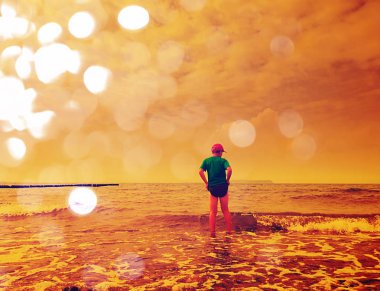 Soyut etkisi. Çocuk sahilde okyanus içine gidin. Köpüklü denizin dalgaları oyunda çocuk.