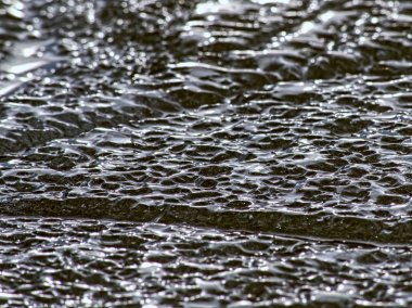 Buzlar siyah kayalık kumsalda kırma. Kademeli erime ile siyah kum buza kırık 