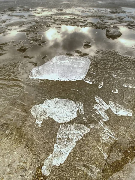 Куча сияющего льда на пляже. Лед в бухте покрыт сильным ветром. Грязный пляж — стоковое фото
