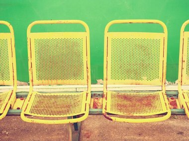 Açık stadyum çalarlarda Vintage çelik koltuk sandalye yeşil duvar altında aşınmış boya ile tezgah