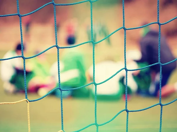 Fußballtornetz. Fußballtornetz. im verschwommenen Hintergrund stehen Spieler. — Stockfoto