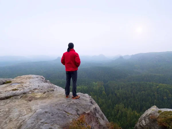 O homem no topo do pico da montanha no céu nublado do nascer do sol. Desporto e ativo — Fotografia de Stock