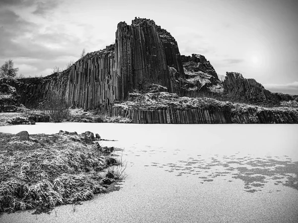 Nuit de pleine lune, la roche volcanique enneigée et gelée avec les nuages volants et le lac gelé — Photo