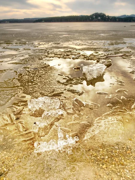 Winter natural wonder. Yellow pieces of snow melting on beach. Wonderful nature c — Stock Photo, Image