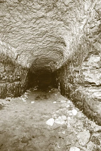 El viejo túnel de agua, cuevas minadas. La cueva. túnel de arenisca paredes humedecidas . — Foto de Stock