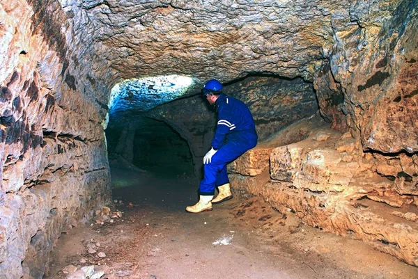 Trabajador con casco y traje protector usando brillos y lámpara de cabeza fuerte. El hombre hace trabajo — Foto de Stock