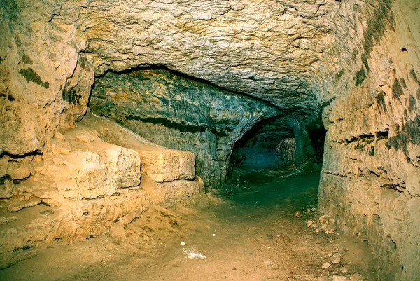 View into an empty medieval catacomb. Tunnel excavated in orange sandstone rock — Stock Photo, Image